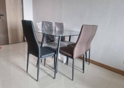Modern dining area with glass table and four chairs