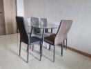 Modern dining area with glass table and four chairs