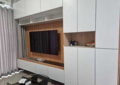 Living room with white cabinets and wall-mounted TV