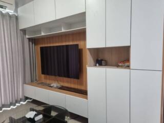 Living room with white cabinets and wall-mounted TV