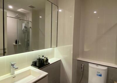 Modern bathroom with vanity, large mirror, and toilet