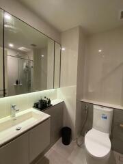 Modern bathroom with vanity, large mirror, and toilet