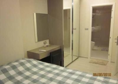 Bedroom with desk, checkered bed, and mirrored closet doors