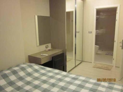 Bedroom with desk, checkered bed, and mirrored closet doors