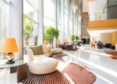 Luxurious modern lobby with large windows, seating areas, and natural light