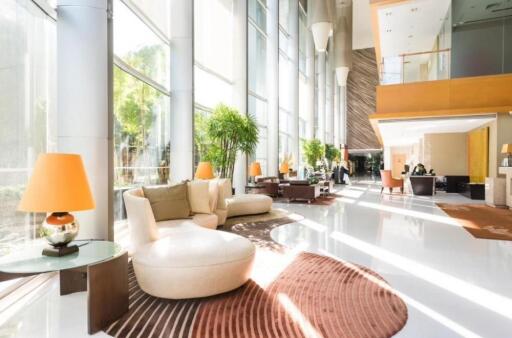 Luxurious modern lobby with large windows, seating areas, and natural light