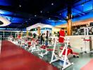 Modern gym with various exercise equipment under ambient lighting