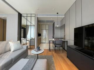 Modern living room with adjacent dining area and view into the bedroom