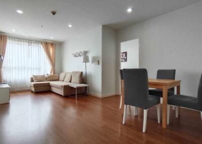 Spacious living room with wooden flooring, neutral tones, and large windows