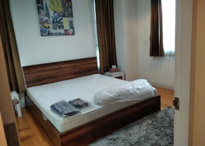 Bedroom with wooden bed frame and artwork on wall