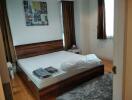 Bedroom with wooden bed frame and artwork on wall