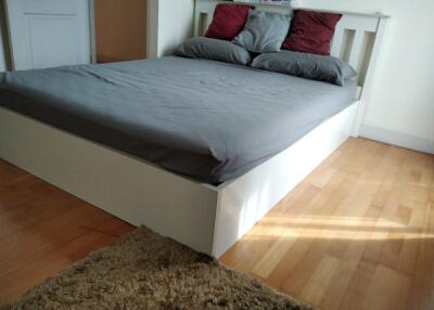 Modern bedroom with grey bedding and wooden floor