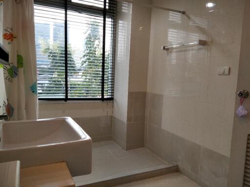 Bathroom with window, basin, and shower area