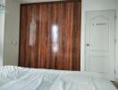 Bedroom with wooden wardrobe and white door