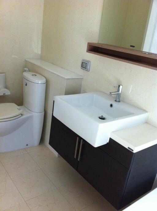 Modern bathroom with sink, toilet, and mirror