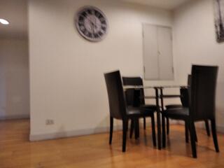 Small dining area with glass table and four black chairs