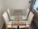 Modern dining area with glass table and wooden chairs