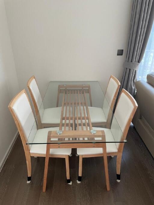 Modern dining area with glass table and wooden chairs