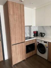 Modern kitchen with wooden cabinets, appliance, and marble backsplash