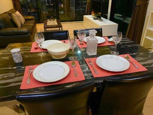 Dining area with table set for four, adjacent to living room