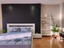 Modern bedroom with a black accent wall, bed, and shelving unit