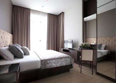 Modern bedroom with double bed, mirrored wardrobe, and a TV