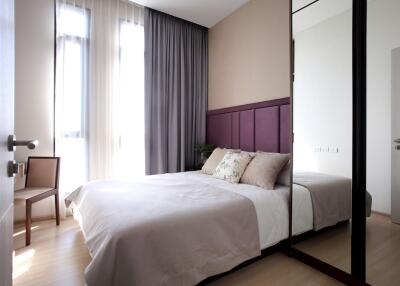 Modern bedroom with large windows and floor-to-ceiling curtains