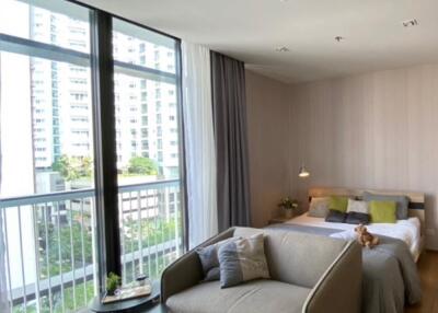 Modern bedroom with large windows and a seating area