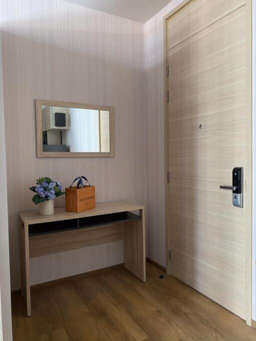 Modern entrance with a wooden door and a small table