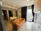 Modern living room with brown sofa, dining area, and balcony view