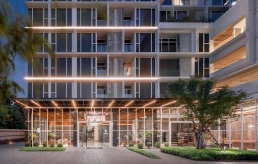 Modern multi-story apartment building with illuminated facade