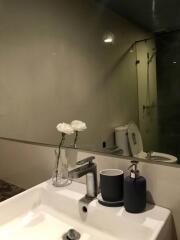 Modern bathroom with vanity, flowers, and shower