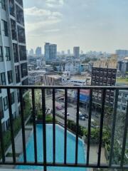 City view from an apartment balcony with a pool below