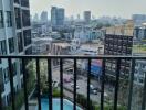 City view from an apartment balcony with a pool below