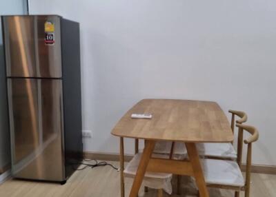 Minimalist kitchen area with a dining table and refrigerator