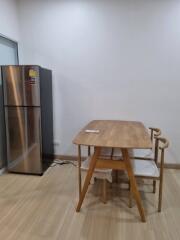 Minimalist kitchen area with a dining table and refrigerator