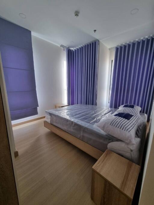 Modern bedroom with wooden furniture and purple curtains