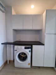 Compact laundry area with washing machine and storage cabinets