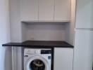 Compact laundry area with washing machine and storage cabinets