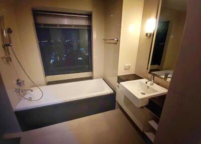 Modern bathroom with a bathtub, window, sink, and mirror