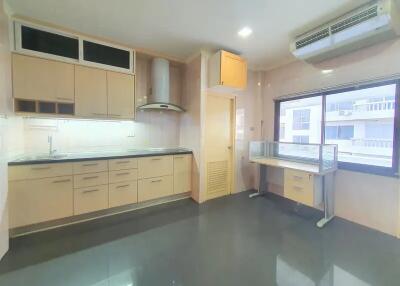 Modern kitchen with built-in cabinets, a range hood, and a bright window