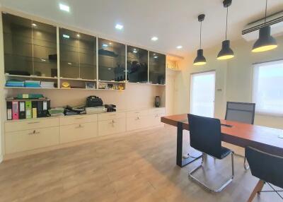 Modern office space with large wooden desk and storage cabinets