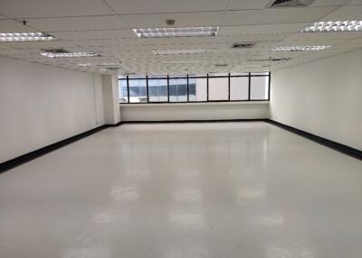 Empty office space with large windows and white floors