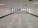 Empty office space with large windows and white floors