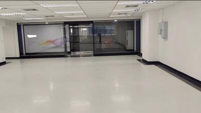 Spacious open-area room with reflective flooring and large glass doors