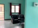 Living room with black leather chairs and large window