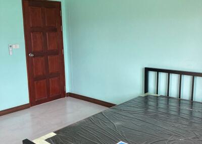 Spacious bedroom with newly painted walls and wooden door