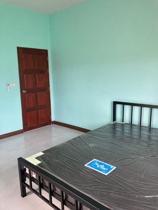 Spacious bedroom with newly painted walls and wooden door