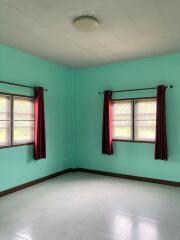 Empty bedroom with windows and red curtains