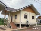 Elevated single-story house with external stairs and a sloped roof